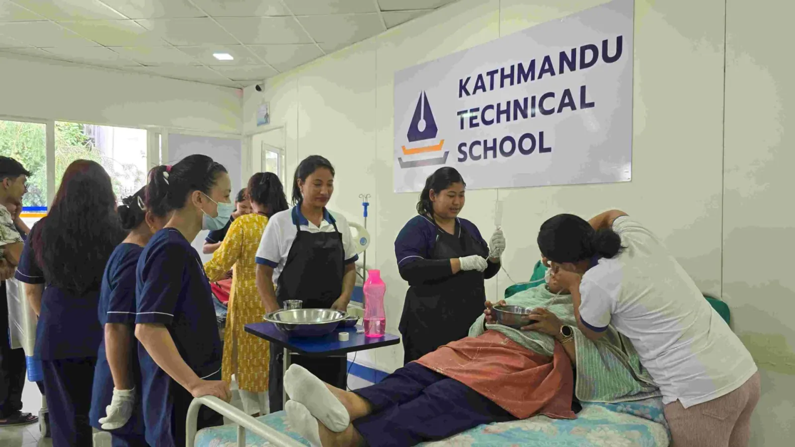 Kathmandu Technical Schoolの受講生がベッド周辺で介護実習に取り組む様子